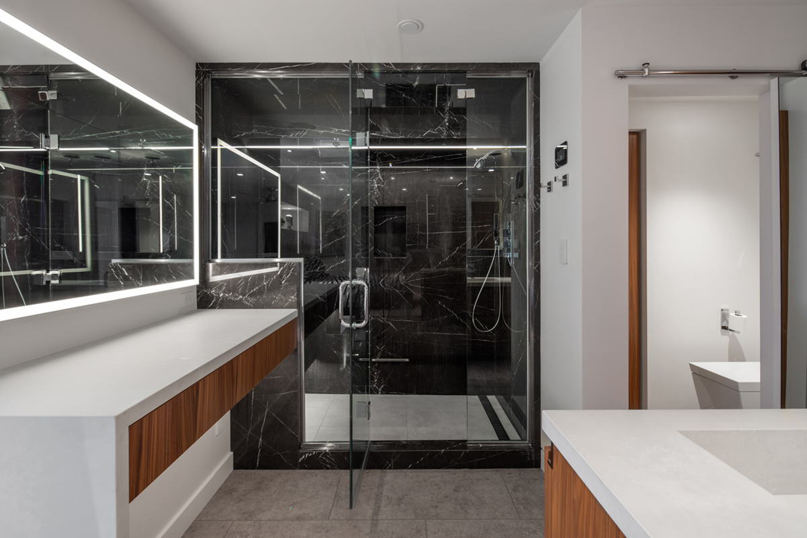 Black marble walk-in shower with frameless glass enclosure