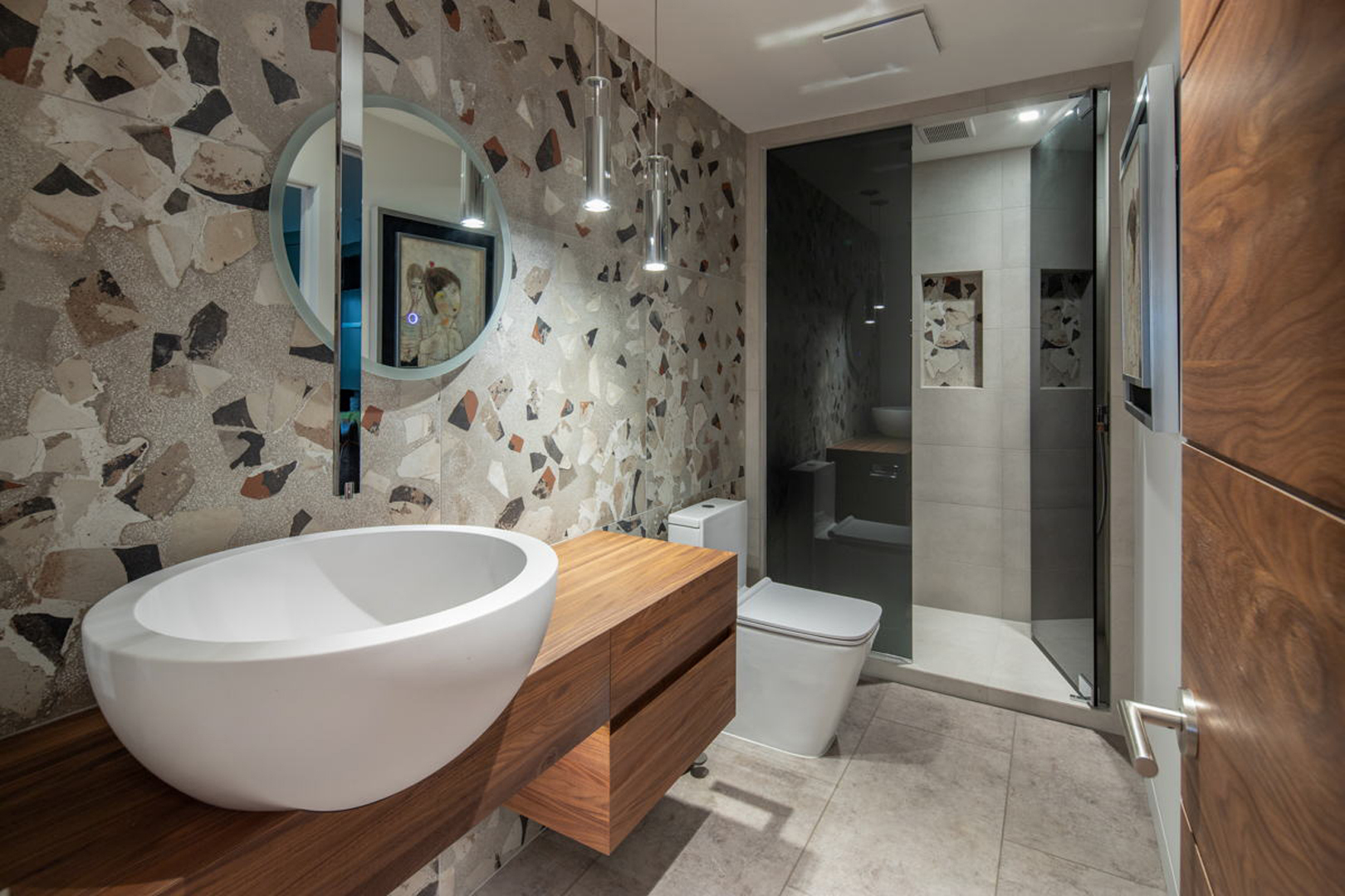 Powder bath wider view with terrazzo tile and glass shower enclosure