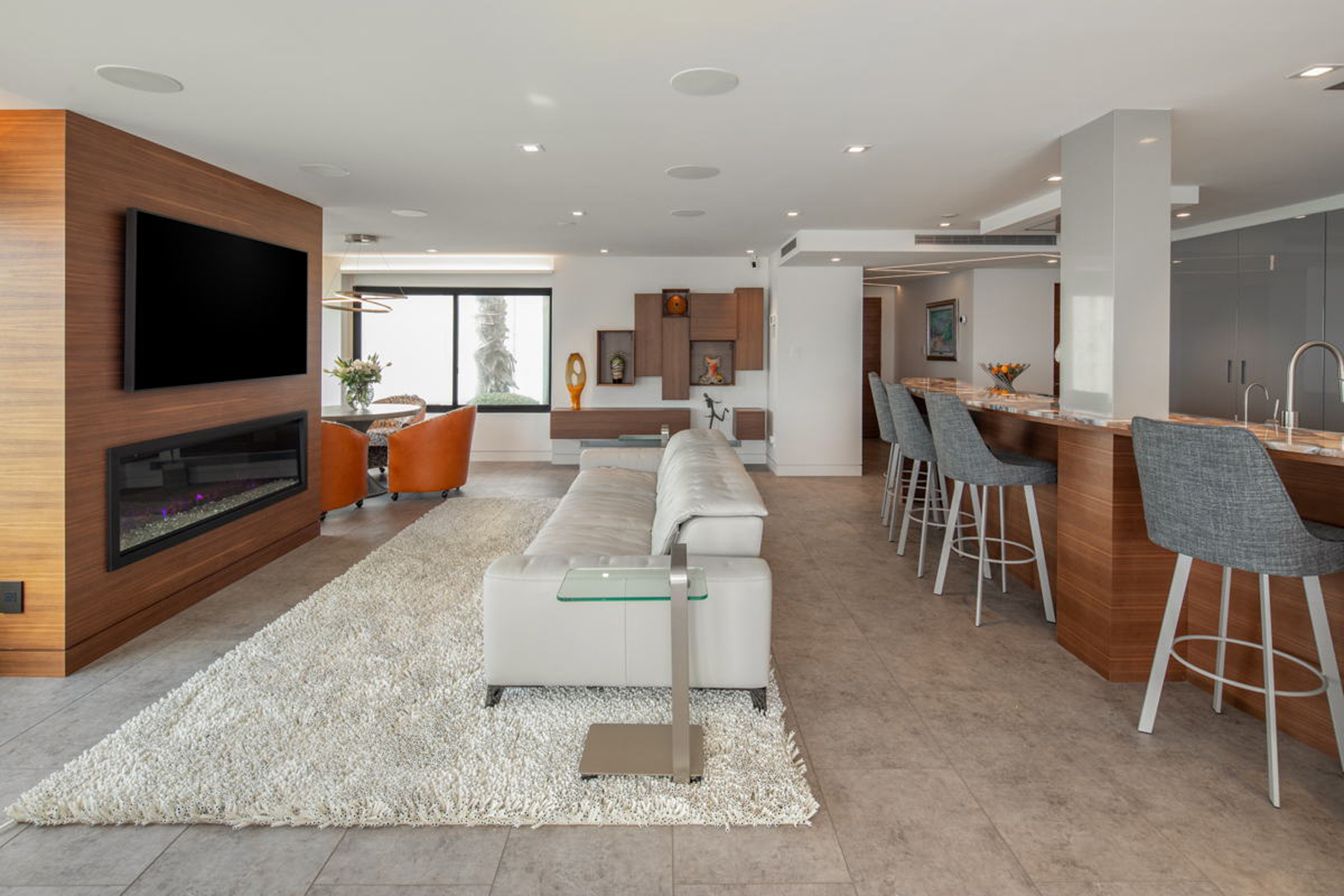 Living room with linear fireplace, bar seating, and white sofa